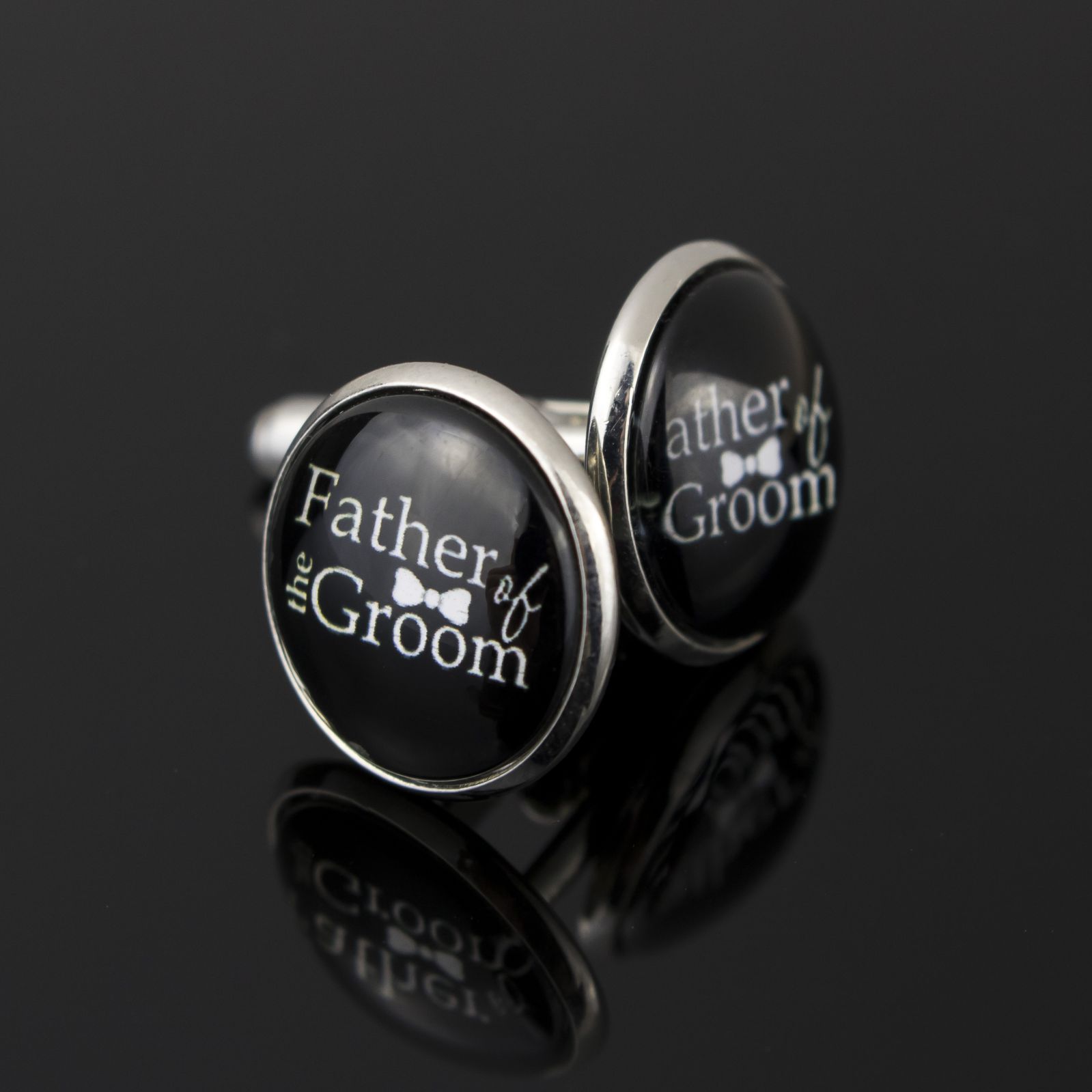 black round cufflinks with father of the groom written in white including a small bow tie in between the words